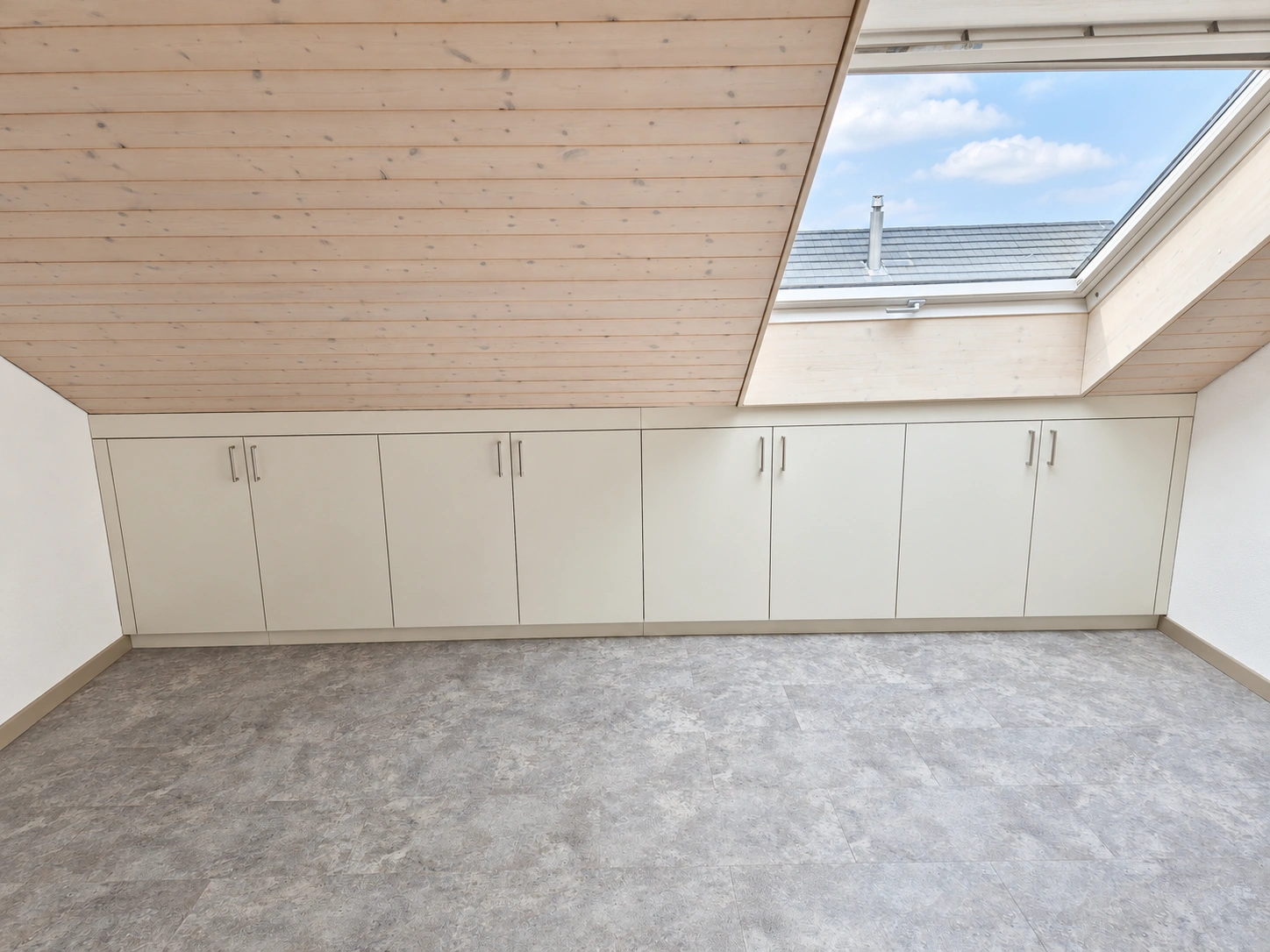 Weisser Einbauschrank unter einer Dachschräge mit Holzdecke und Dachfenster